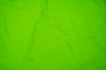 Green color background with little wrinkles. Green recycled craft paper texture as background.
