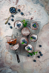 Traditional American oatmeal muffin with blueberries and walnuts served as top view a baking tray