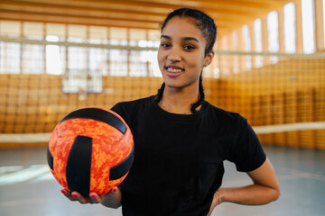 Portrait of a diverse african young female playing volleyball in a sports hall