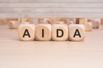 the acronym AIDA is elegantly displayed on a beige hardwood rectangle block