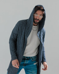 cool casual man with glasses and hoodie posing in a fashion way