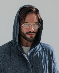 portrait of sexy bearded man with glasses and hoodie looking forward