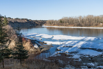 North Saskatchewan river bent in spring season with river water  and  ice along river bank