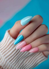 A woman holding a pair of pink and blue nails.
