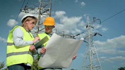 Project team of energy auditors conducting electricity pylon inspection