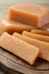 Tasty sweet quince paste on wooden board, closeup