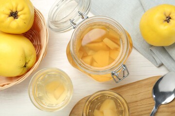Delicious quince drink, fresh fruits and spoon on white wooden table, flat lay