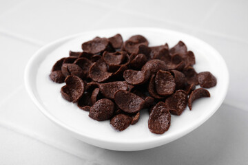 Breakfast cereal. Chocolate corn flakes and milk in bowl on white tiled table, closeup