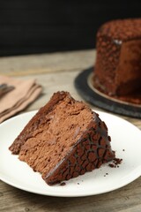 Piece of delicious chocolate truffle cake on wooden table