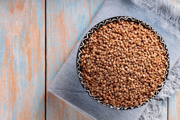 Buckwheat Grains in Bowl on Wooden Background, Healthy and Diet Food Concept, Top View, Copy Space