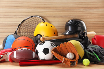 Many different sports equipment on wooden table