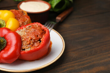 Delicious stuffed bell peppers served on wooden table, closeup. Space for text