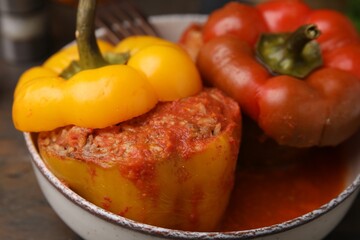 Delicious stuffed bell peppers served on wooden table, closeup