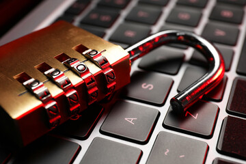 Cyber security. Metal combination padlock on laptop, closeup