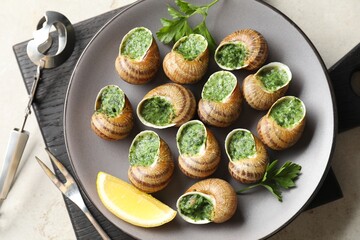 Delicious cooked snails served on light table, flat lay