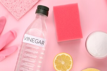 Eco friendly natural cleaners. Flat lay composition with bottle of vinegar on pink background