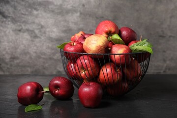 Fresh ripe red apples with water drops in metal bowl on dark grey table