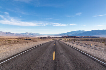 A view along a road leading into Death Valley, with the salt flats in the distance