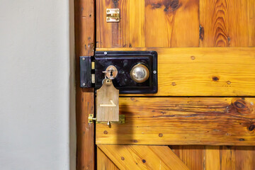 Wooden door with an old handle and locking mechanism. Key in the lock with the Number 1 written on...