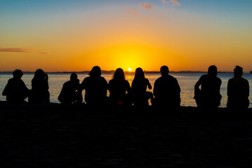 Silhouette of people enjoying the dramatic sunset.