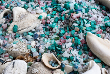 Several colored stones, green and white sea shells together forming a texture.