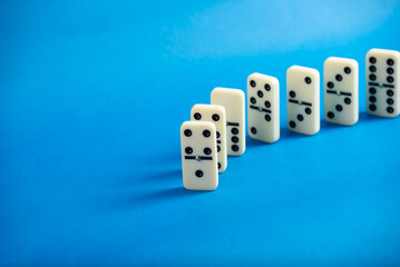 Dominoes standing on a blue background.