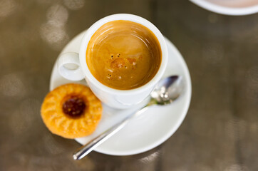 Cup of fresh cortado, Spanish beverage made of espresso with dessert