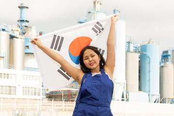 Cheerful asian female worker with south korean flag standing in front of factory