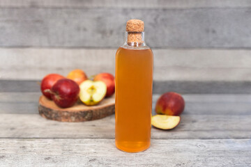 Apple vinegar. Bottle of homemade apple organic vinegar, wine or cider on dark wooden background. Healthy organic food. With copy space.  