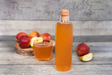 Apple vinegar. Bottle of homemade apple organic vinegar, wine or cider on dark wooden background. Healthy organic food. With copy space.  