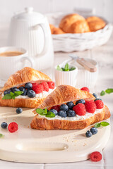 Sweet and hot french croissant with blueberries and raspberries.