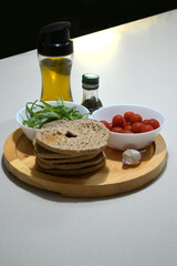 ingredienti della classica frisa barese, con olio extra vergine di oliva, pomodorini, olio, rucola, aglio e prezzemolo