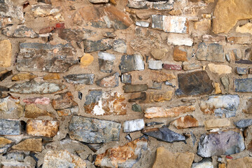 Close-up of a multicolored stone wall, showing detailed texture.