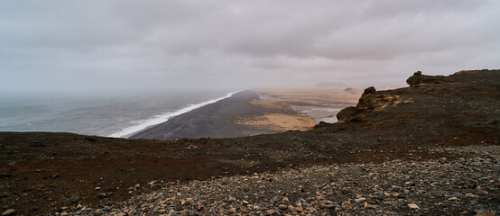 Panoramic view from the viewpoint of the black beach of Dyrhólaey in Iceland on a cloudy day
