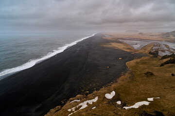 General aerial view of the black beach of Dyrhólaey in Iceland on a cloudy day - Powered by Adobe
