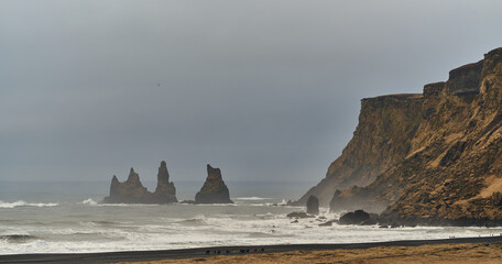 View of Reynisdrangar Basalt Trolls and Black Beach from Vik in Iceland