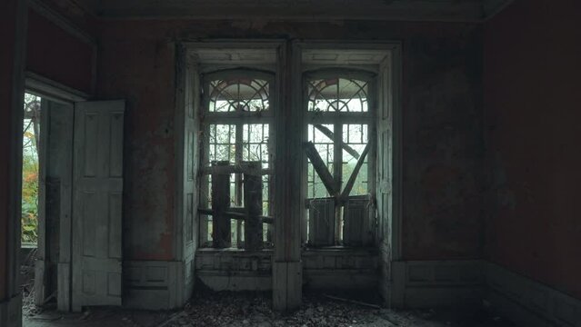 Ventanas tapiadas en una habitaci&oacute;n de una casa abandonada con fondo de naturaleza en un d&iacute;a nublado