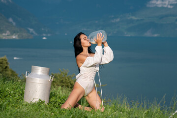 Sexy woman drink milk in Alps. Sexy model with splash of milk. Natural organic milk. Model drink...