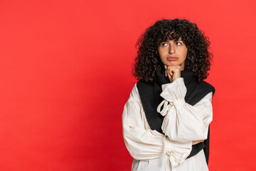 Caucasian young woman with curly hair tired bored indifferent expression, exhausted of tedious story, not interested in communication talk, displeasure, uninteresting. Girl isolated on red background