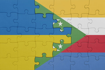 puzzle with the colourful national flag of comoros and flag of ukraine.