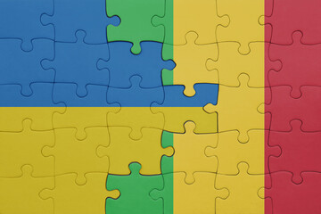 puzzle with the colourful national flag of mali and flag of ukraine.