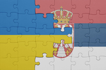 puzzle with the colourful national flag of serbia and flag of ukraine.