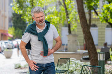 Caucasian mature man feeling sudden strong abdominal stomach ache, gastritis problem. Upset tourist...