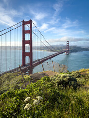 Scenic view of Golden Gate Bridge and cityscape of San Francisco, California, USA at sunrise against blue sky with clouds