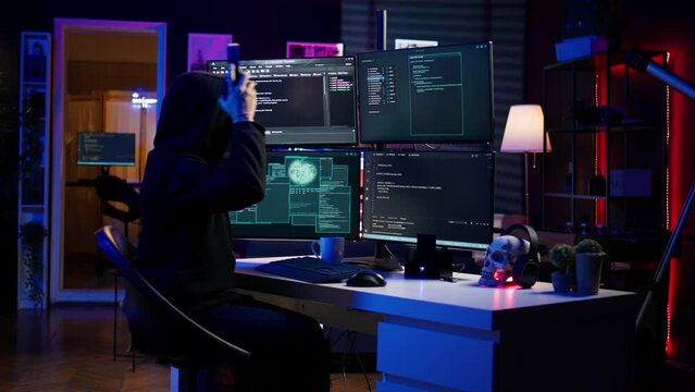 Hacker stealing credit card numbers while listening music through headphones. Evil developer programming in apartment, infiltrating banking systems, hearing songs, camera B