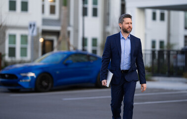 Business man in classic suit, blue jacket and white shirt. Fashion man in suit walk outdoors. Businessman in fashion suit walking in city. Business fashion street style. Man in trendy suit. Modern