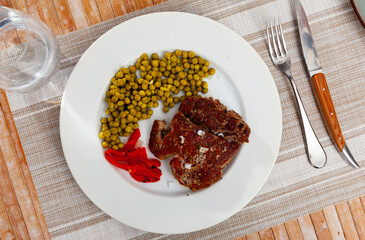 Tender beef meat cooked over open fire, with appetizing crust and dark stripes and traces from...