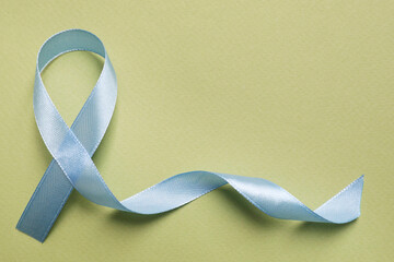 International Psoriasis Day. Ribbon as symbol of support on green background, top view. Space for...