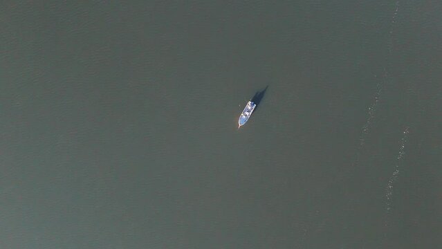 Descending Aerial Of Fishermen Fishing From Small Boat. Dique la Angostura - Taf&iacute; del Valle