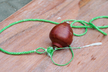 Gasing, a traditional game that uses wood and rope. Apart from gasing, this game is also known by several terms such as gangsing, panggal, pukang, begasing, apiong, and maggasing.